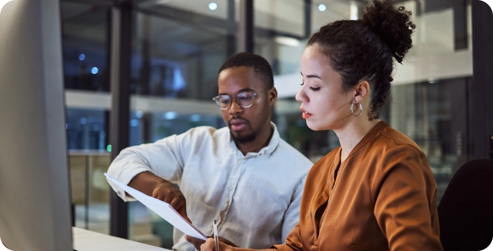 Two colleagues reviewing paperwork together.