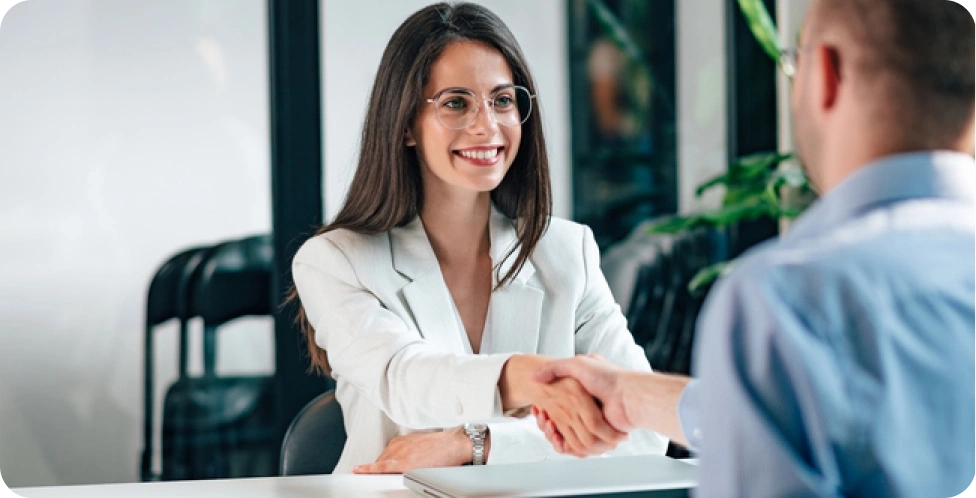 Woman and man shaking hands in interview.